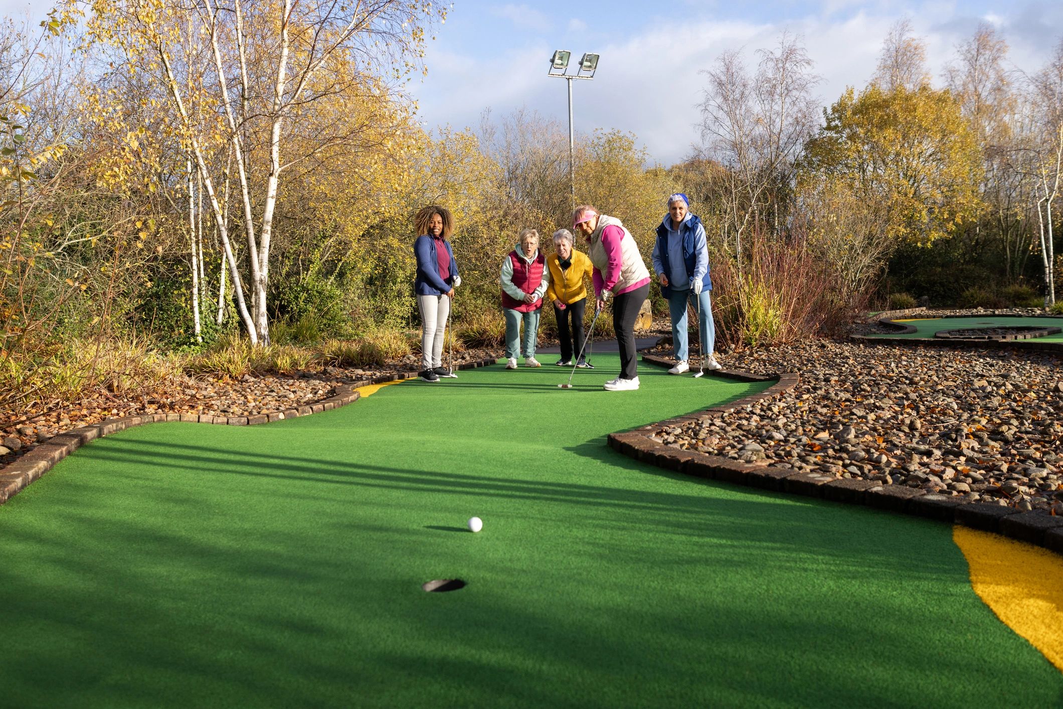 Golfers taking a shot on a mini golf course